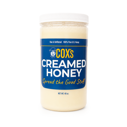 A jar of COX's Creamed Honey with a white lid and a blue label, photographed on a clean white background.