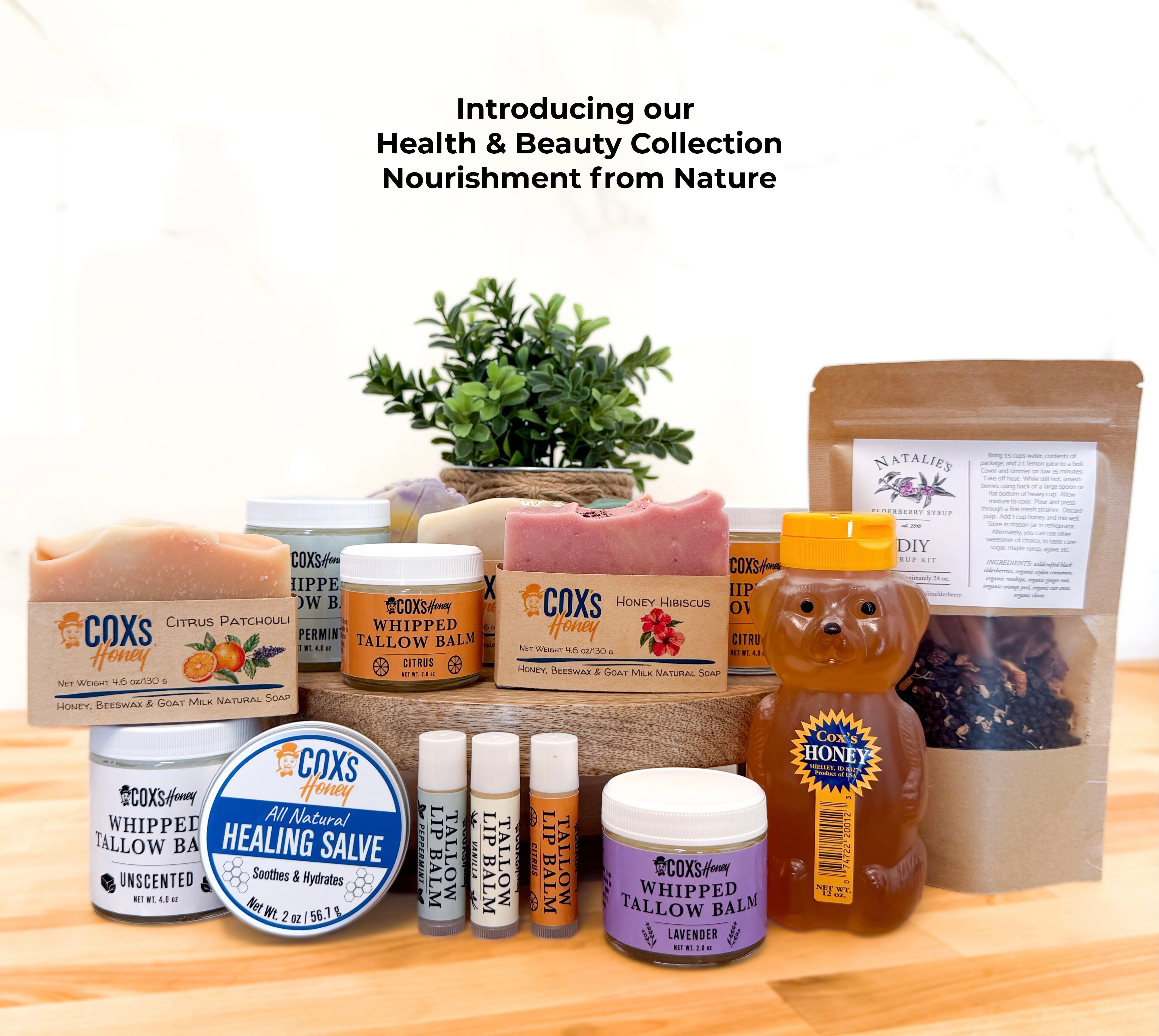 Collection of Coxs Honey & Soap products on a wooden surface with a plant in the background.