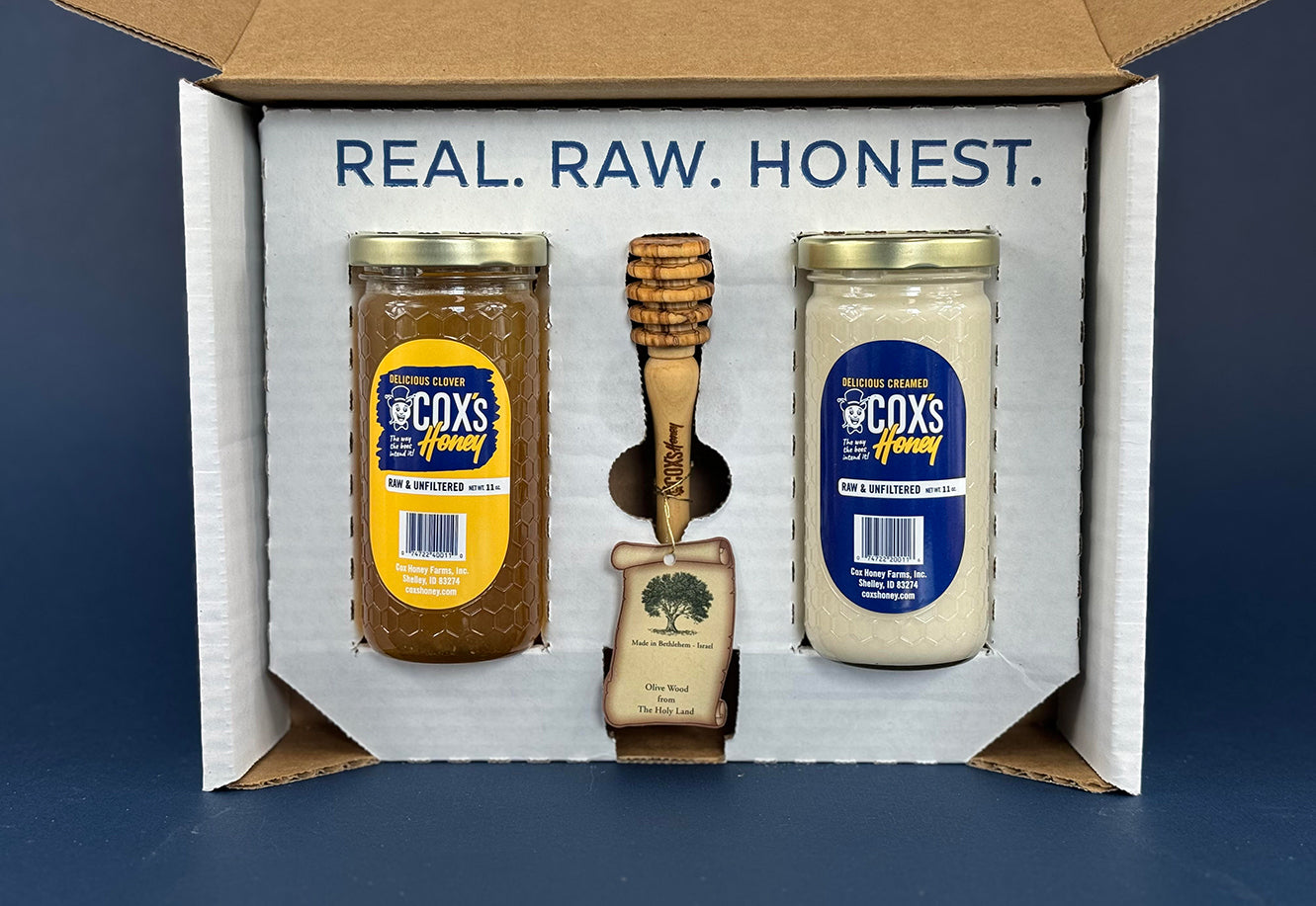 Cox's Honey gift set with 1 - 11 oz clover honey glass jar and 1 - 11 oz creamed honey glass jar and 1 olive wood honey dipper inside the gift box