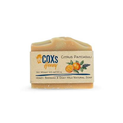 Bar of citrus patchouli soap with a Coxs Honey label on a white background