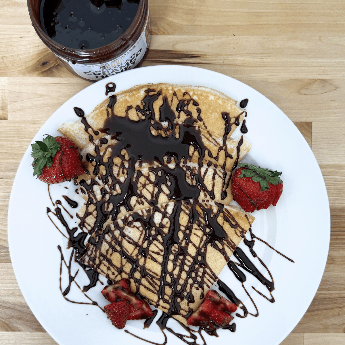 Cox's 20 oz chocolate honey drizzled on crepes with strawberries