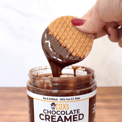 Coxs Honey 20 oz Chocolate Creamed Honey with a waffle dipped into the chocolate honey and pulling it out