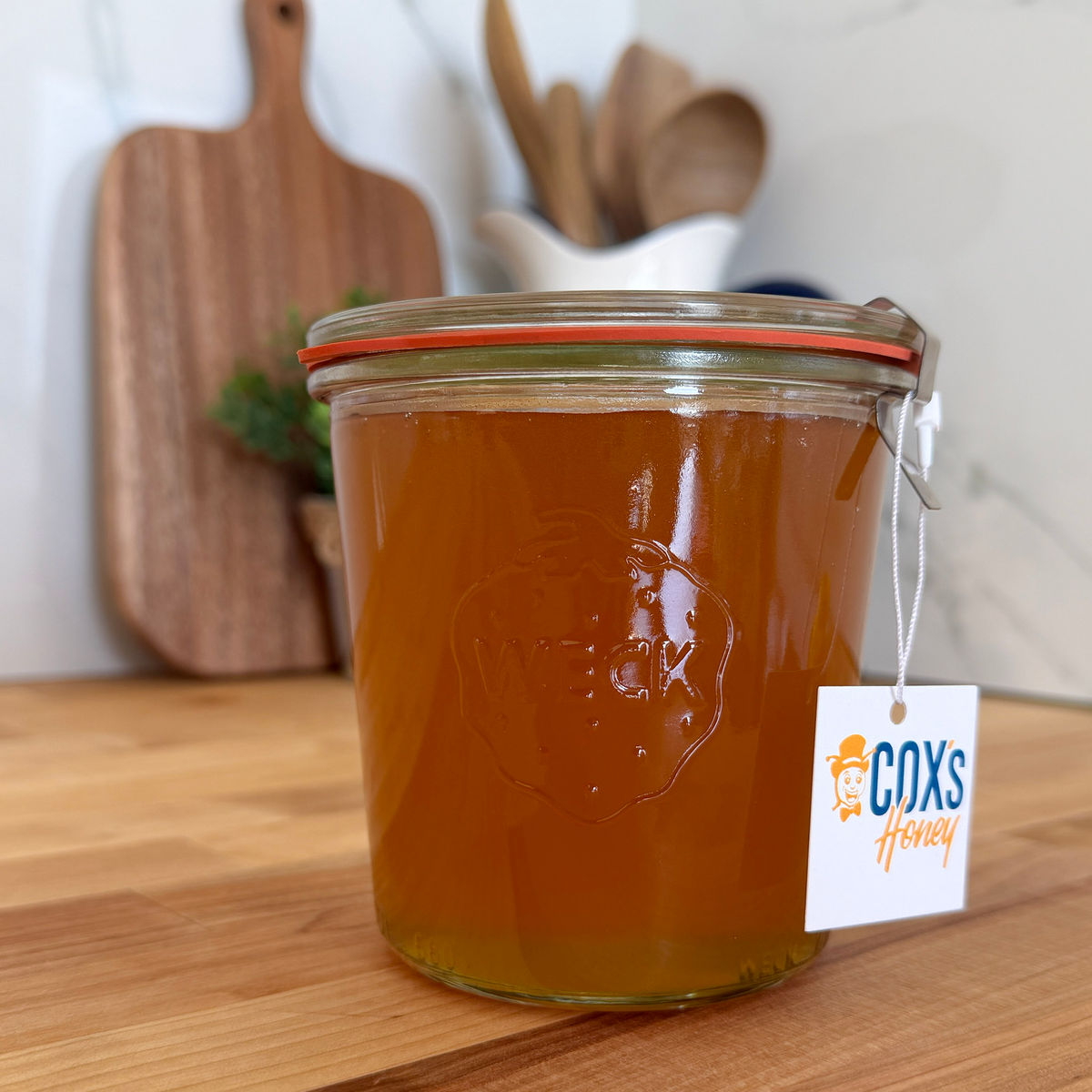 Coxs Honey 24 oz Weck Jar sitting on a wood block