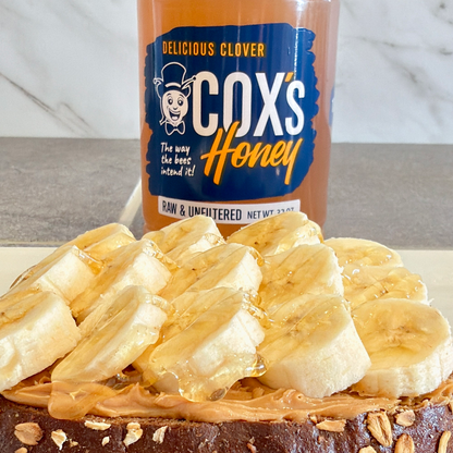 Cox's Honey jar with a dessert topped with banana slices and peanut butter.