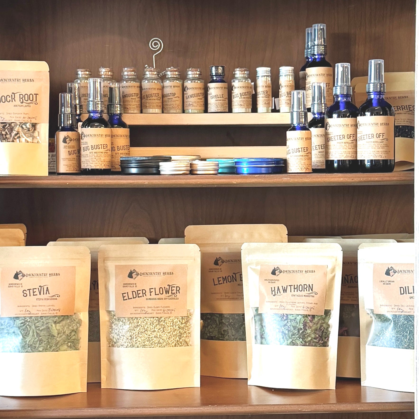 Shelf displaying various herbal products including bottles and bags with labels.