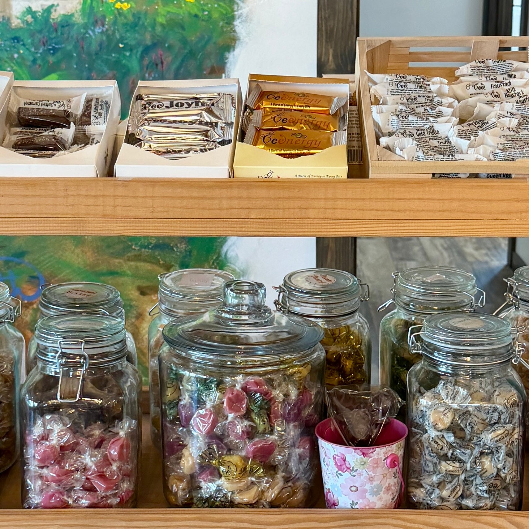 Shelf with jars of confectionery and boxes of tea or similar products.