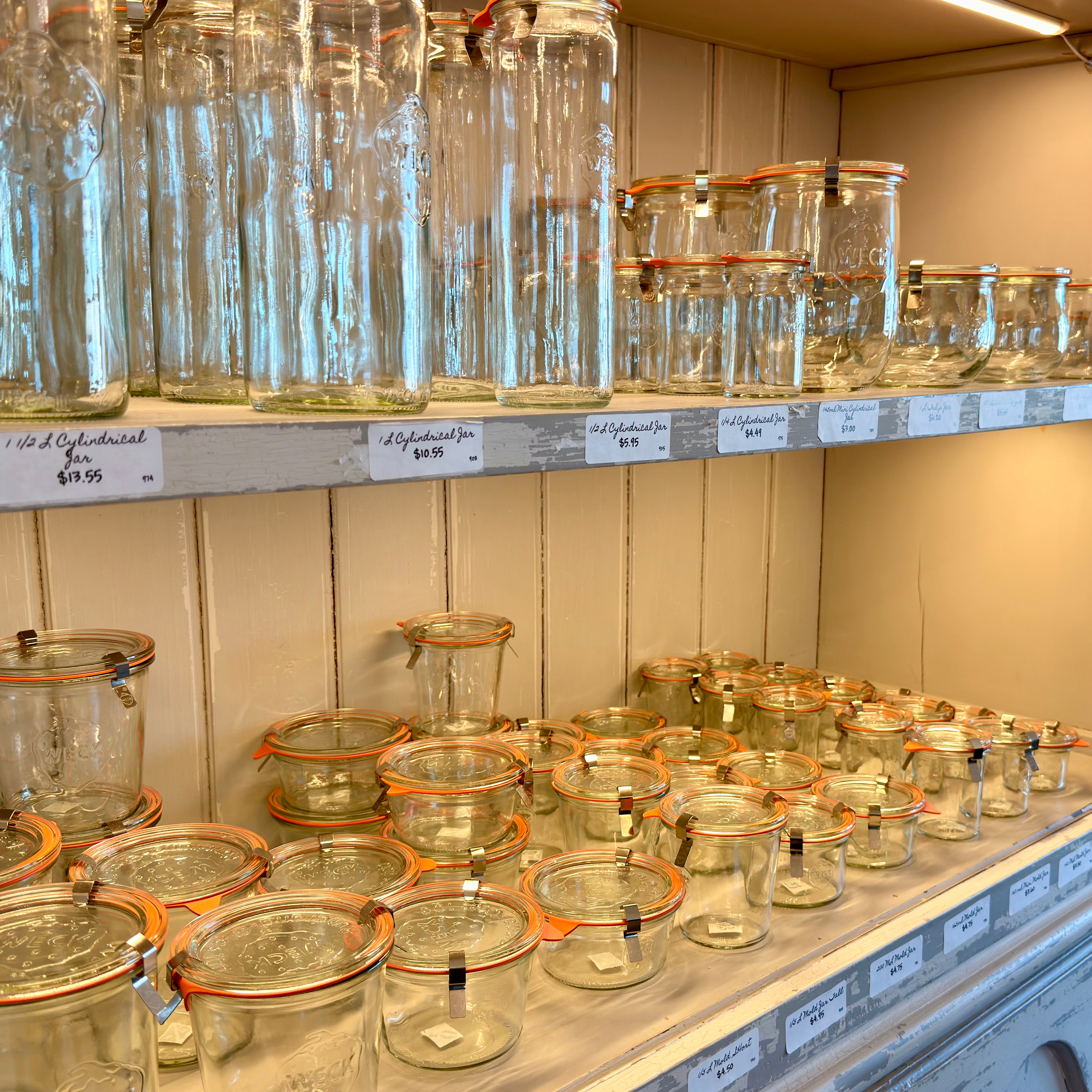 Shelves with glass jars on a white wall background