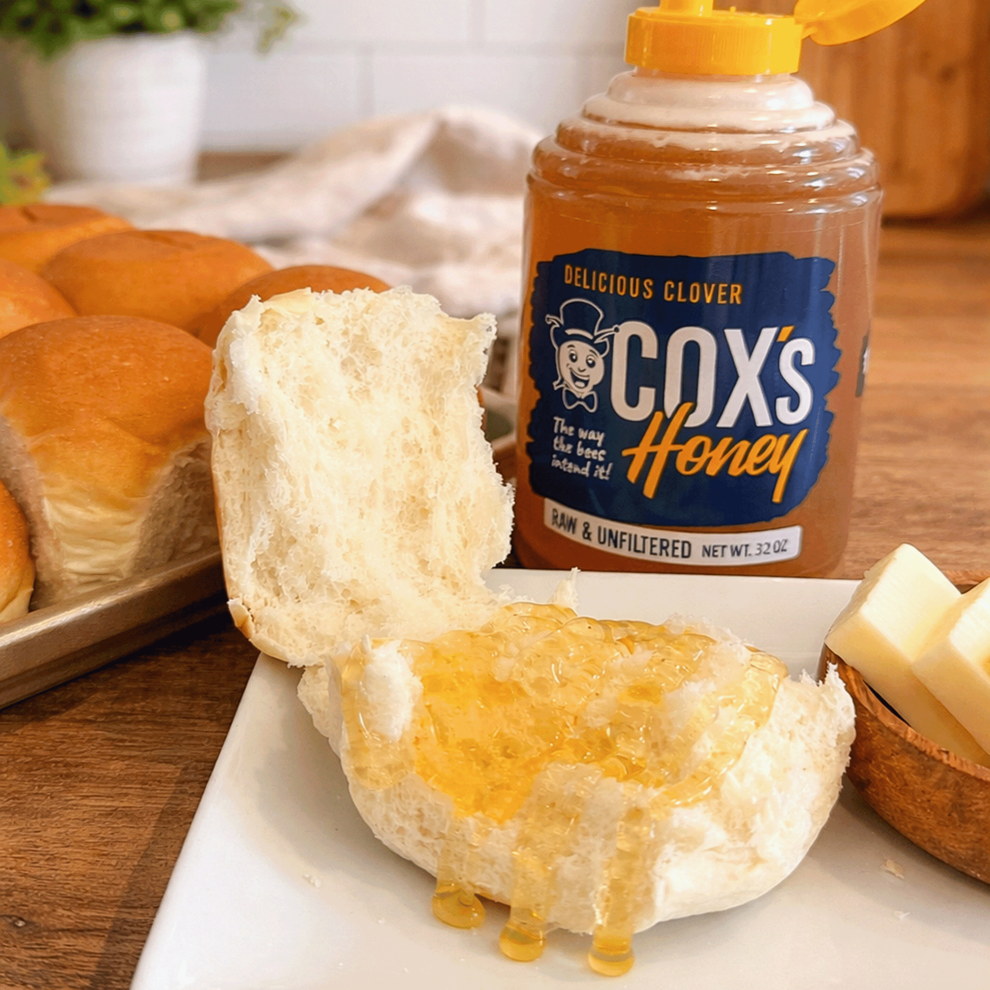 Honey spread on a biscuit with a jar of Cox's Honey in the background.